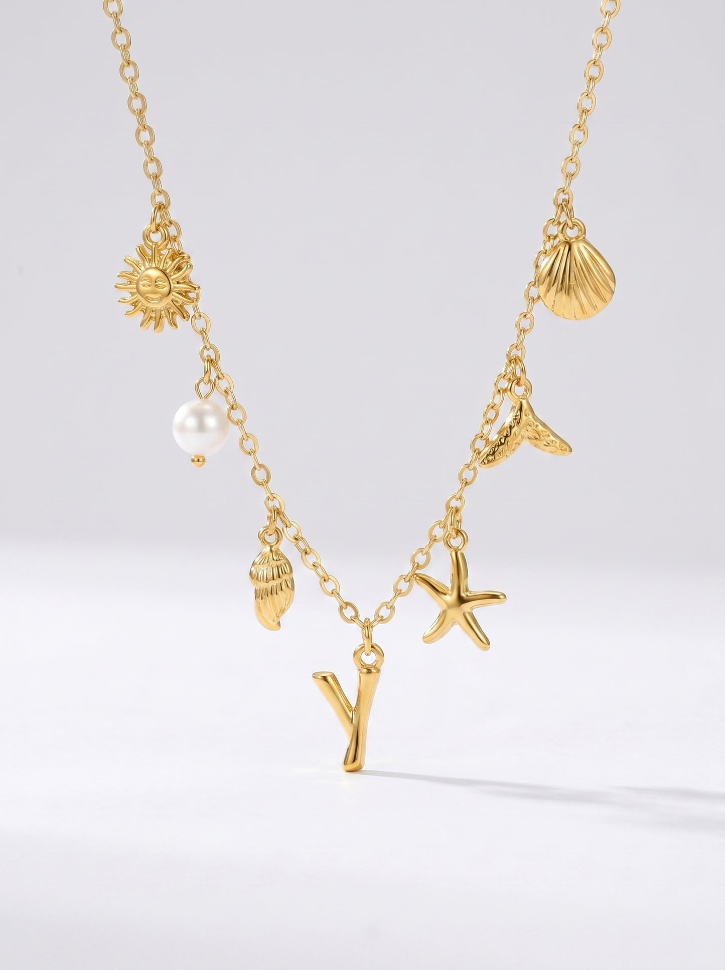 Colar dourado do mar com letra inicial Y, estrela-do-mar, conchas, pérola e pendente de sol.