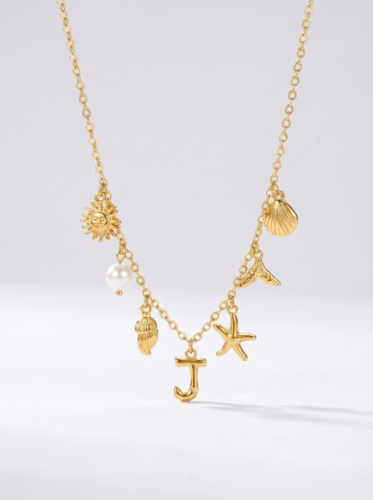 Colar dourado do mar com letra inicial J, estrela-do-mar, conchas, pérola e pendente de sol.