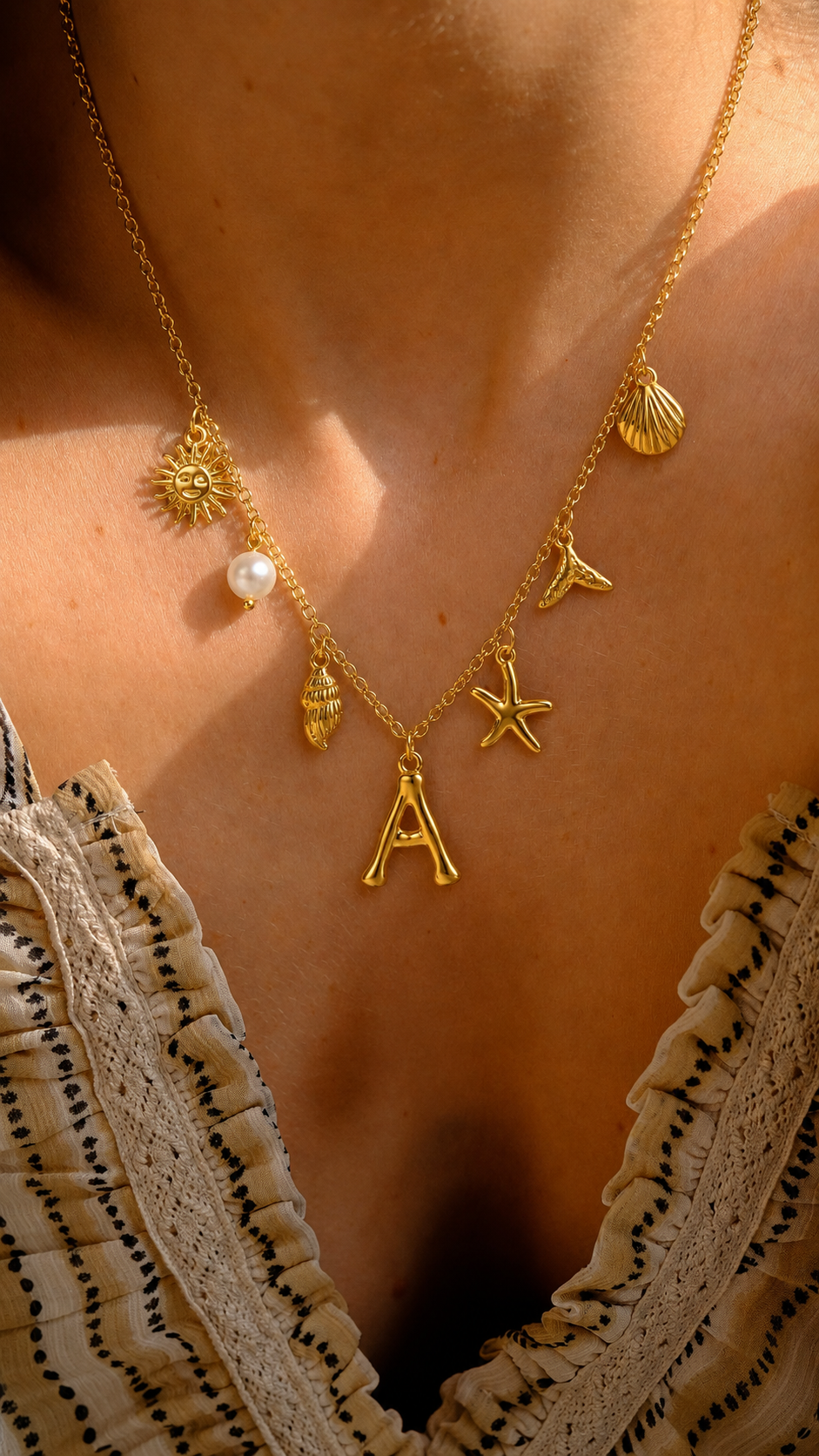 Colar dourado do mar com letra inicial A, estrela-do-mar, conchas, pérola e pendente de sol.