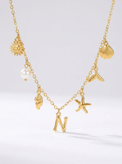 Colar dourado do mar com letra inicial N, estrela-do-mar, conchas, pérola e pendente de sol.