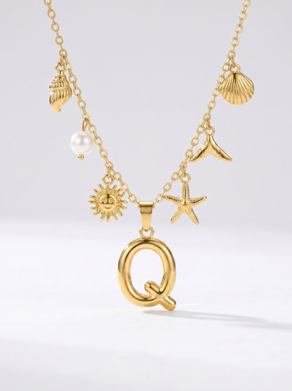 Colar dourado do mar com letra inicial Q, estrela-do-mar, conchas, pérola e pendente de sol.