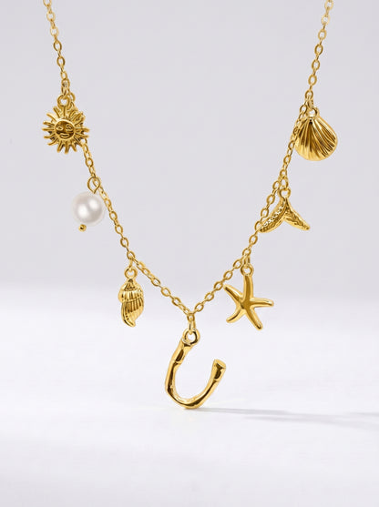 Colar dourado do mar com letra inicial U, estrela-do-mar, conchas, pérola e pendente de sol.