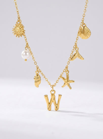 Colar dourado do mar com letra inicial W, estrela-do-mar, conchas, pérola e pendente de sol.