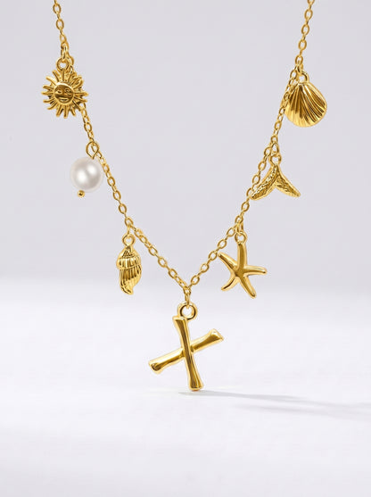 Colar dourado do mar com letra inicial X, estrela-do-mar, conchas, pérola e pendente de sol.