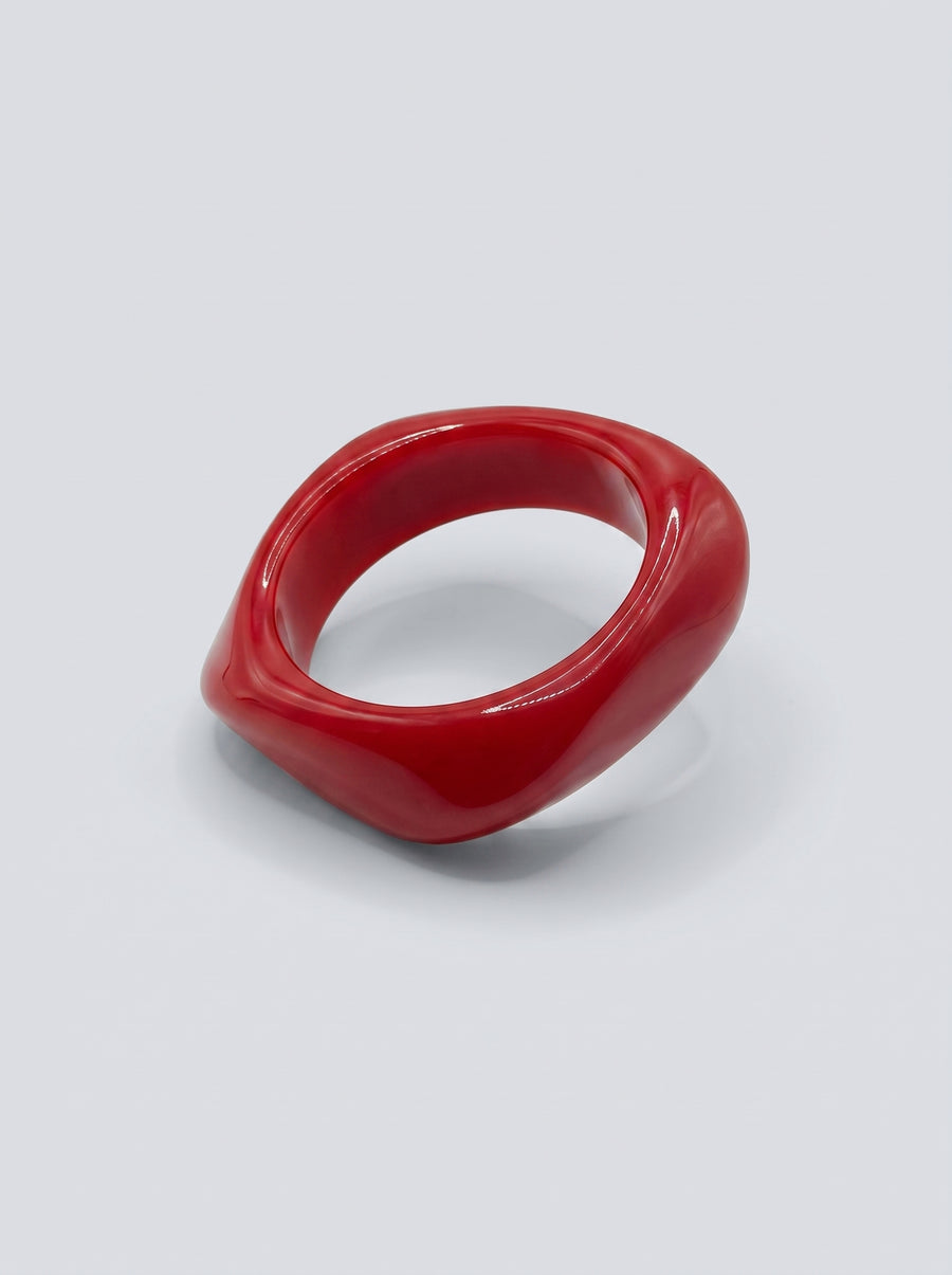 Pulseira Cereja em resina marmoreada nos tons cereja e vermelho profundo, com design orgânico geométrico e acabamento brilhante, ideal para um look elegante e contemporâneo.
