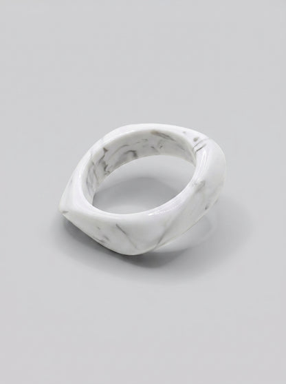 Pulseira Mármore em resina marmoreada nos tons mármore branco e cinza, com design orgânico geométrico e acabamento brilhante, ideal para um look elegante e contemporâneo.
