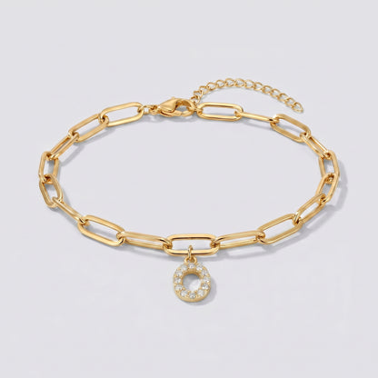 Pulseira dourada com letra inicial O, corrente paperclip e pendente de letra cravejado.