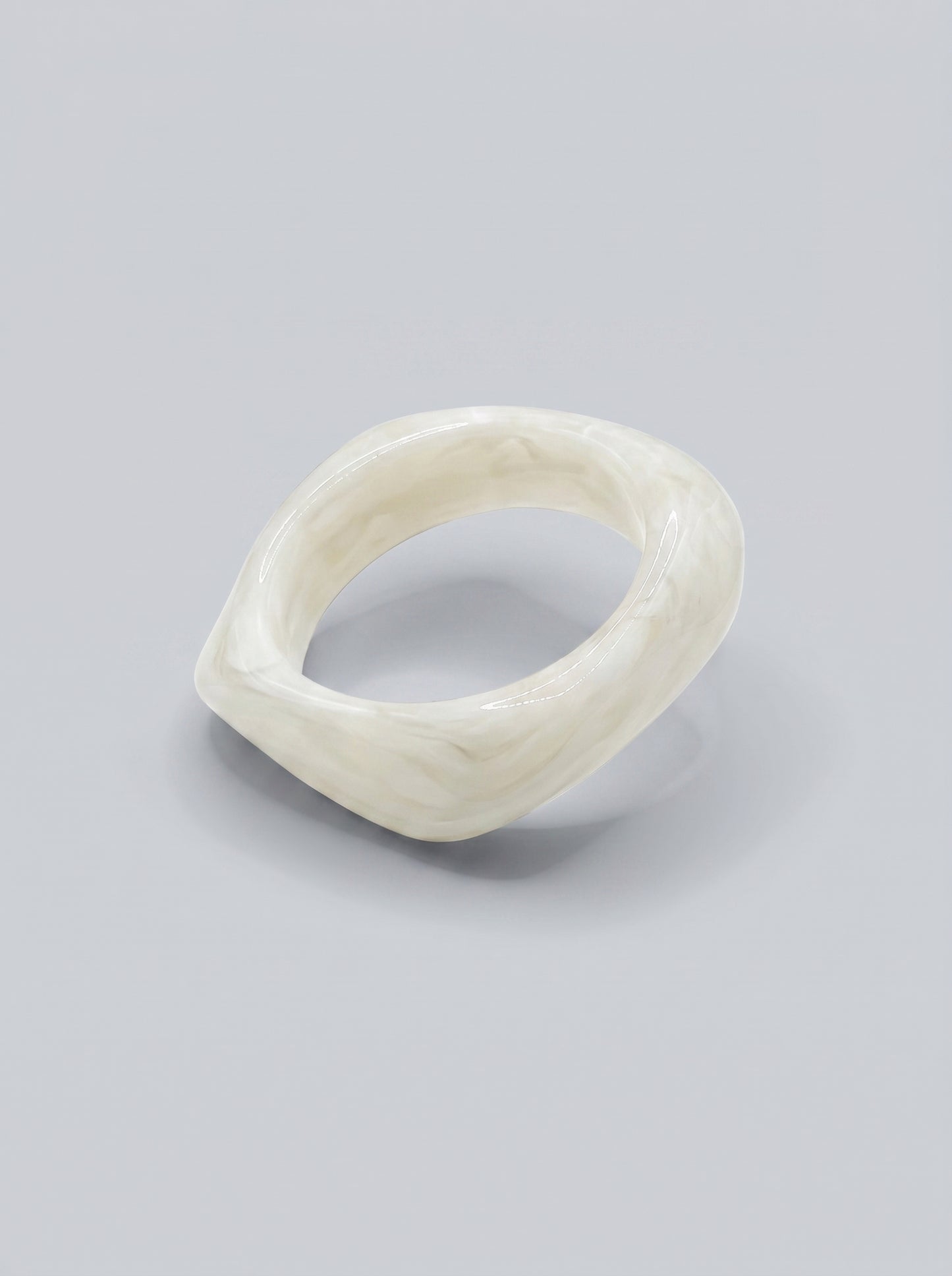 Pulseira Pérola em resina marmoreada branca, com design orgânico geométrico e acabamento brilhante, ideal para um look elegante e contemporâneo.