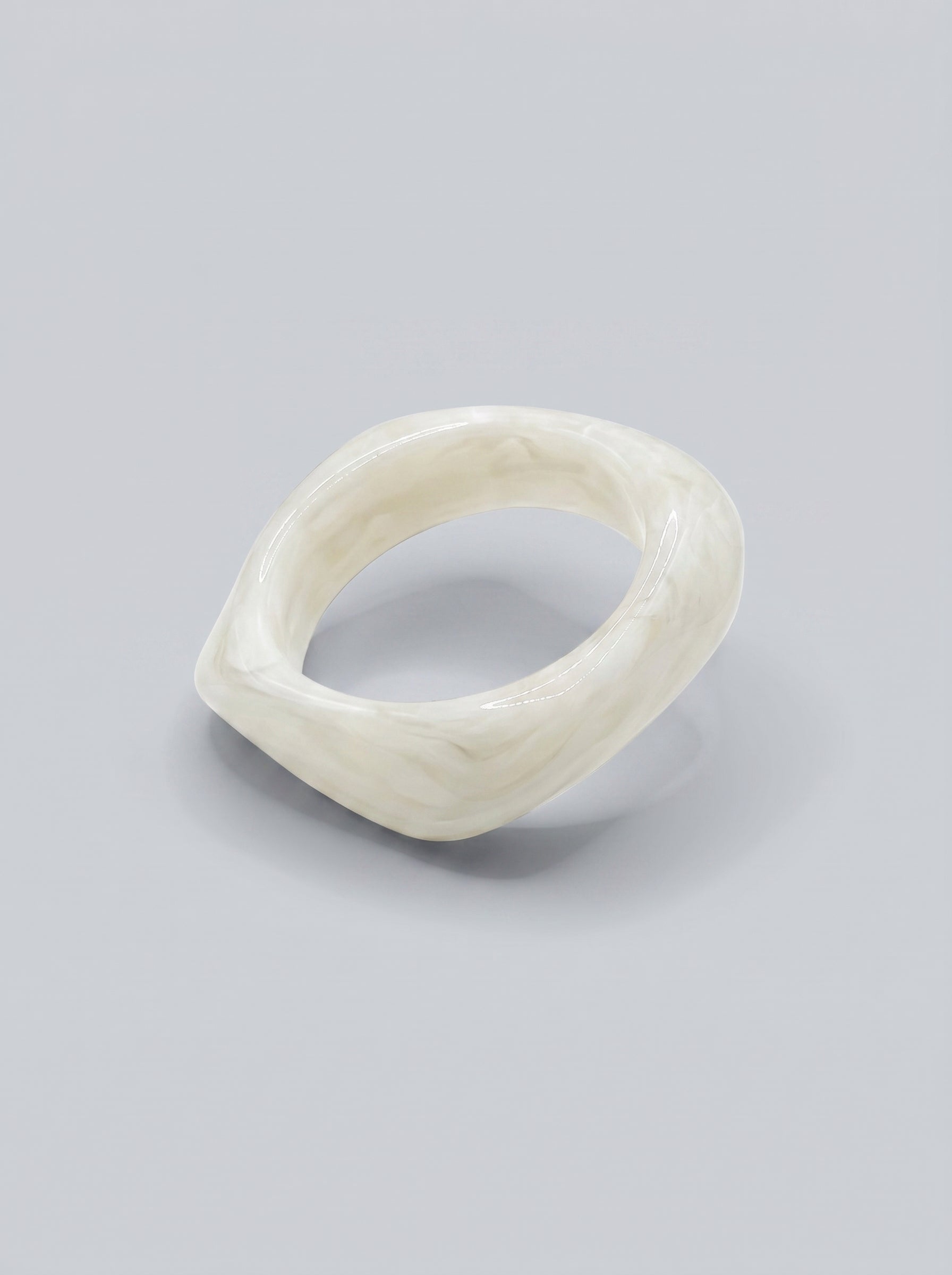 Pulseira Pérola em resina marmoreada branca, com design orgânico geométrico e acabamento brilhante, ideal para um look elegante e contemporâneo.