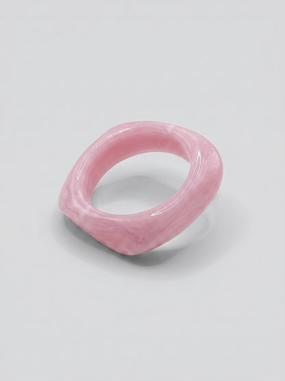 Pulseira Quartzo Rosa em resina marmoreada nos tons quartzo rosa e blush, com design orgânico geométrico e acabamento brilhante, ideal para um look elegante e contemporâneo.
