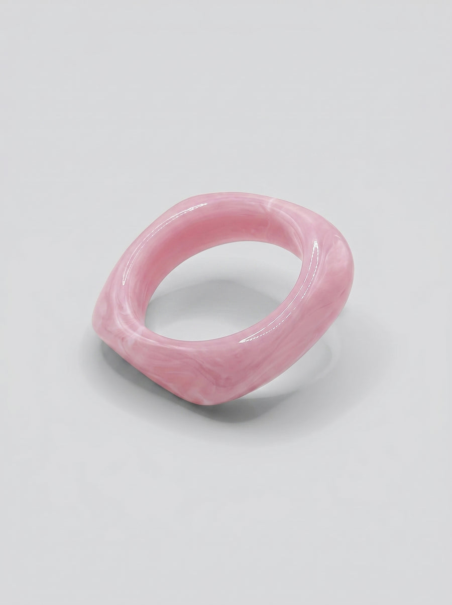 Pulseira Quartzo Rosa em resina marmoreada nos tons quartzo rosa e blush, com design orgânico geométrico e acabamento brilhante, ideal para um look elegante e contemporâneo.
