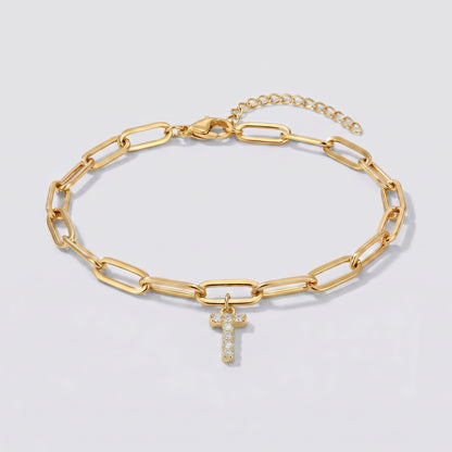 Pulseira dourada com letra inicial T, corrente paperclip e pendente de letra cravejado.
