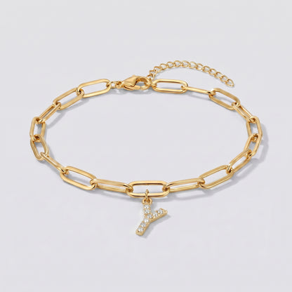 Pulseira dourada com letra inicial Y, corrente paperclip e pendente de letra cravejado.