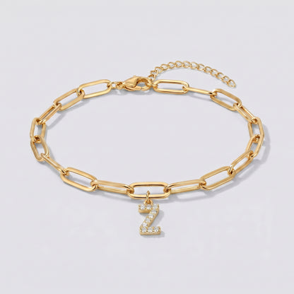 Pulseira dourada com letra inicial Z, corrente paperclip e pendente de letra cravejado.