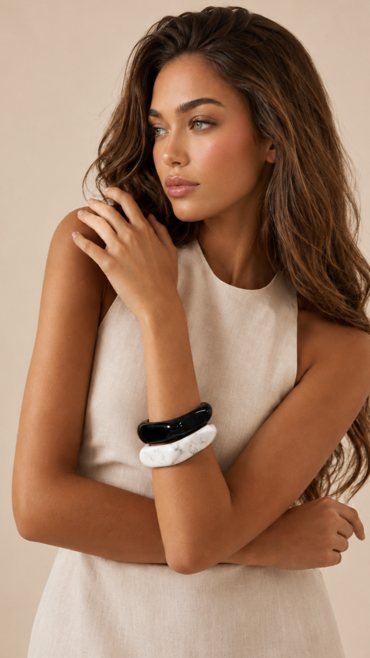 Pulseiras de resina preta e branca usadas por modelo, com acabamento brilhante e estilo elegante.
