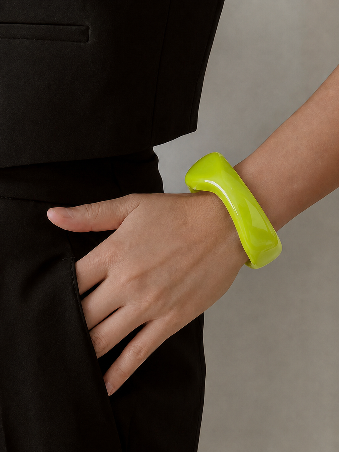 Pulseira de resina verde lima usada no pulso, com acabamento brilhante e estilo elegante.
