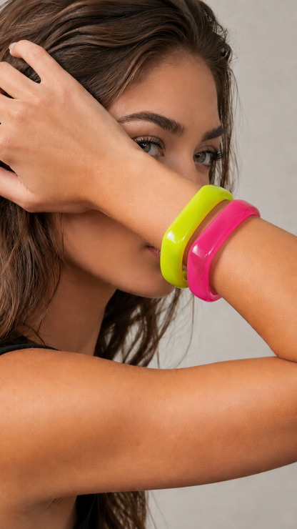 Pulseiras de resina verde lima e rosa usadas por modelo, com acabamento brilhante e estilo elegante.