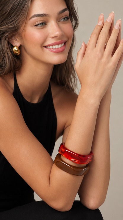 Pulseiras de resina vermelha e castanha usadas por modelo, com acabamento brilhante e estilo elegante.