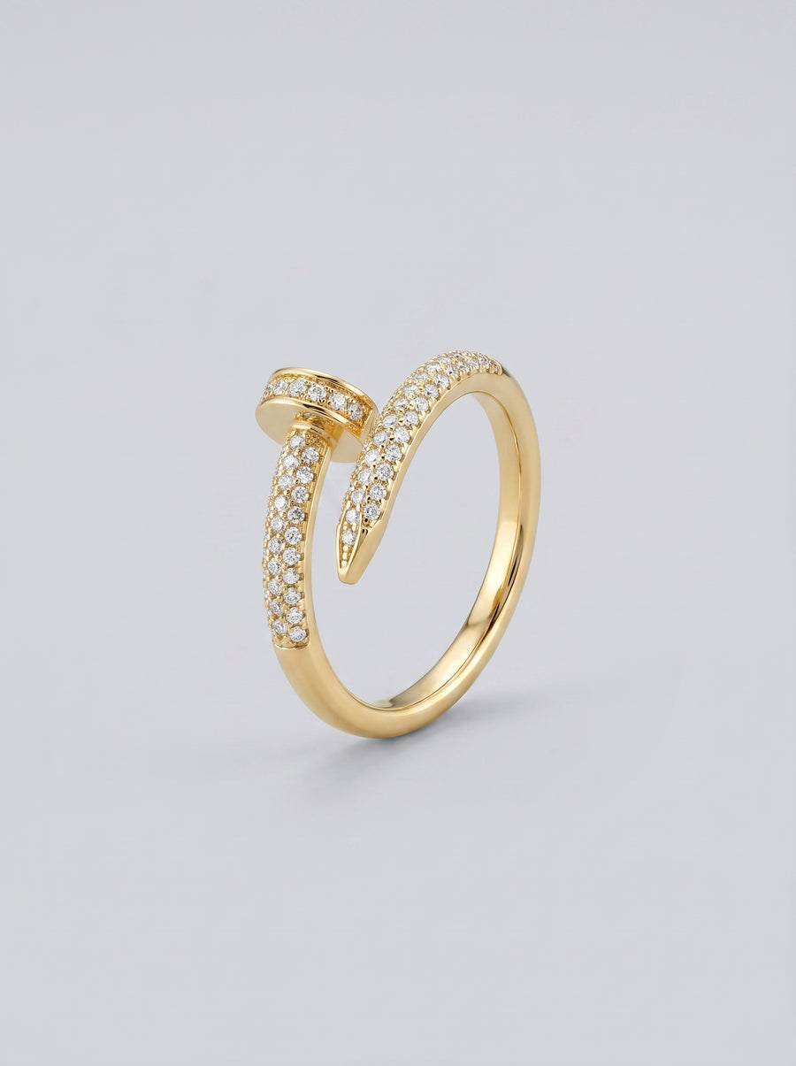 Anel em ouro com detalhes em diamante sobre fundo cinza claro.
