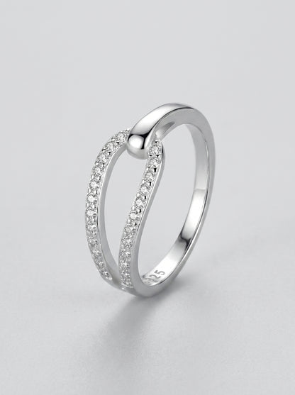Anel em prata com pequenos diamantes sobre fundo cinzento claro.
