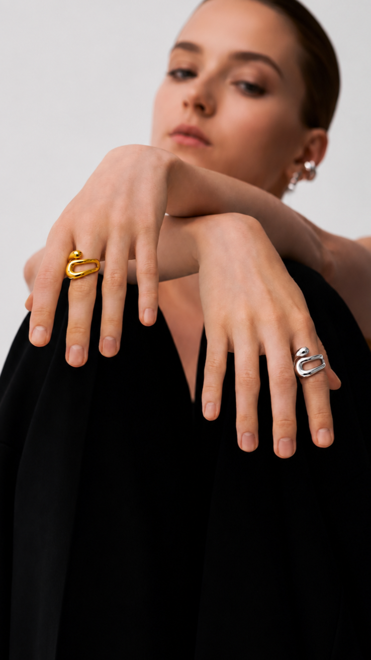 Modelo com anel dourado e anel prateado de design moderno em fotografia editorial de joalharia.