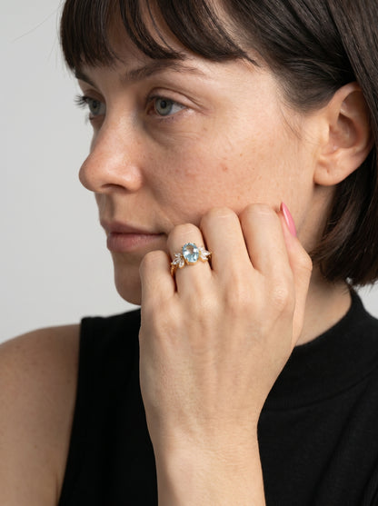 Mulher a usar um anel com um diamante no dedo contra um fundo neutro.