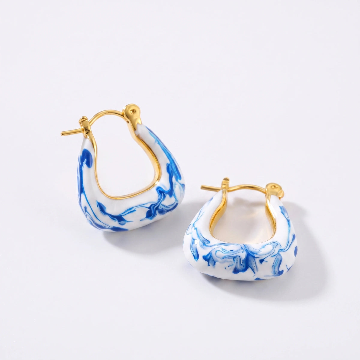 Brincos argola em esmalte branco e azul mármore, banho dourado