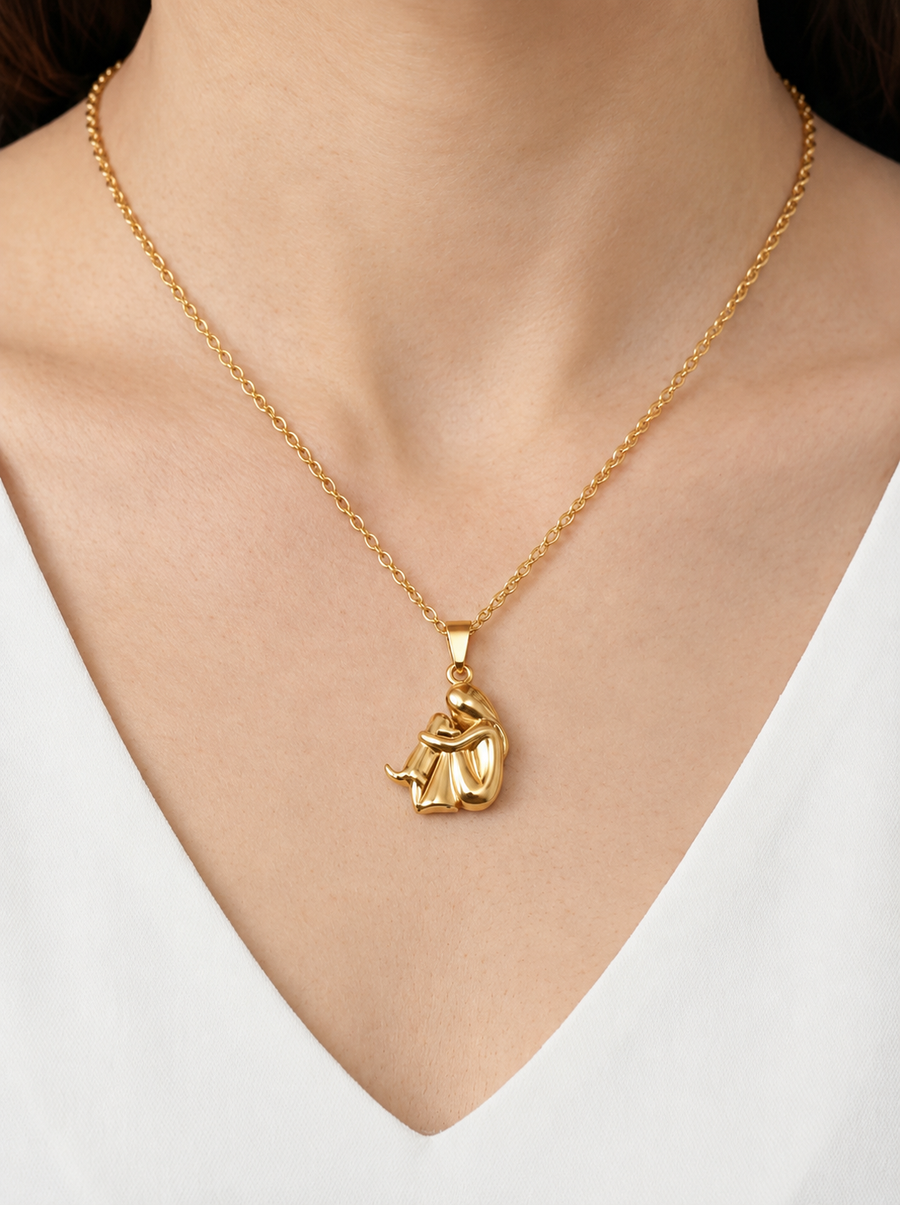 Colar dourado delicado com pendente artístico abstrato e acabamento brilhante, usado ao pescoço para um visual moderno, elegante e sofisticado.