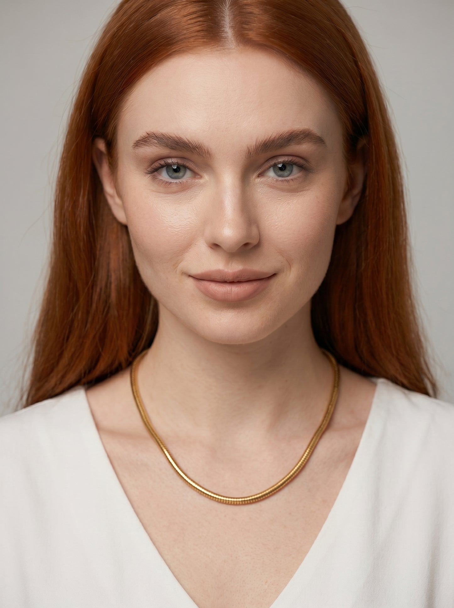 Colar dourado moderno com acabamento texturizado e design minimalista, usado por uma modelo para um visual elegante, artístico e sofisticado.