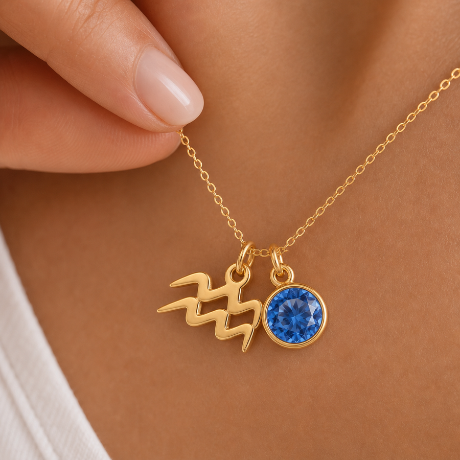 Mulher a usar colar dourado com símbolo do signo Aquário e pedra azul, em destaque sobre o peito.