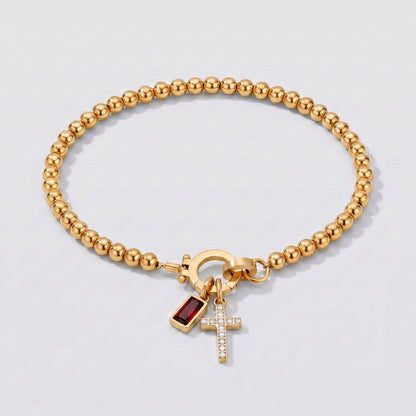 Pulseira dourada de contas com cruz e pedra de nascimento granada de janeiro.