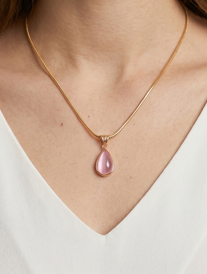 Colar dourado delicado com pendente rosa em forma de gota e acabamento elegante, usado ao pescoço para um visual feminino, sofisticado e delicado.