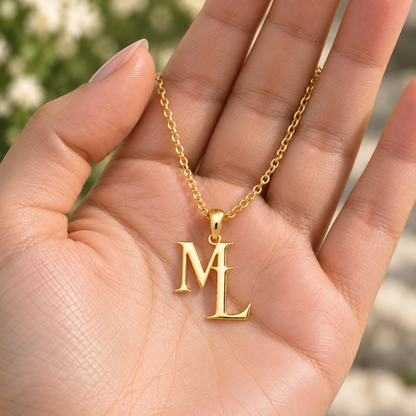 Colar dourado com iniciais M e L apresentado na mão