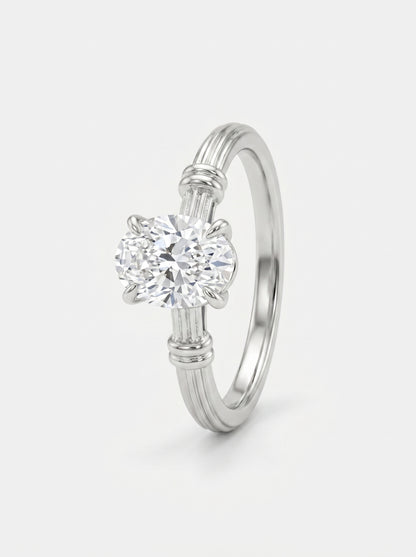 Anel em prata com diamante sobre fundo cinzento claro.
