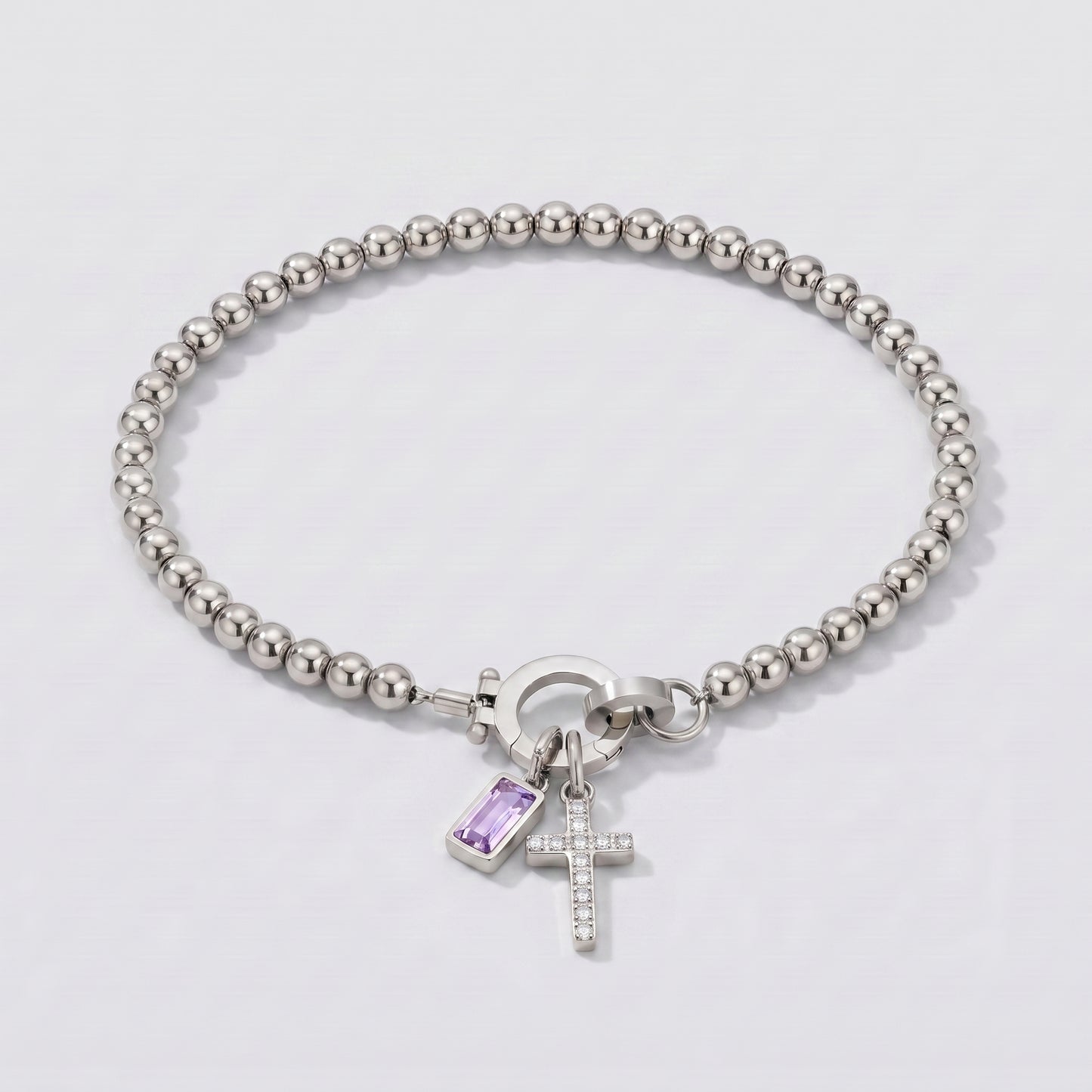 Pulseira prateada de contas com cruz e pedra de nascimento alexandrite lilás de junho.