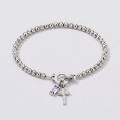 Pulseira prateada de contas com cruz e pedra de nascimento alexandrite lilás de junho.