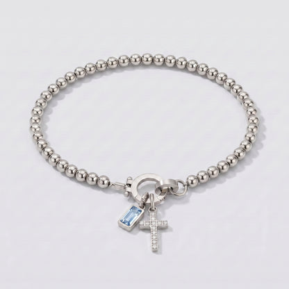 Pulseira prateada de contas com cruz e pedra de nascimento água-marinha azul clara de março.