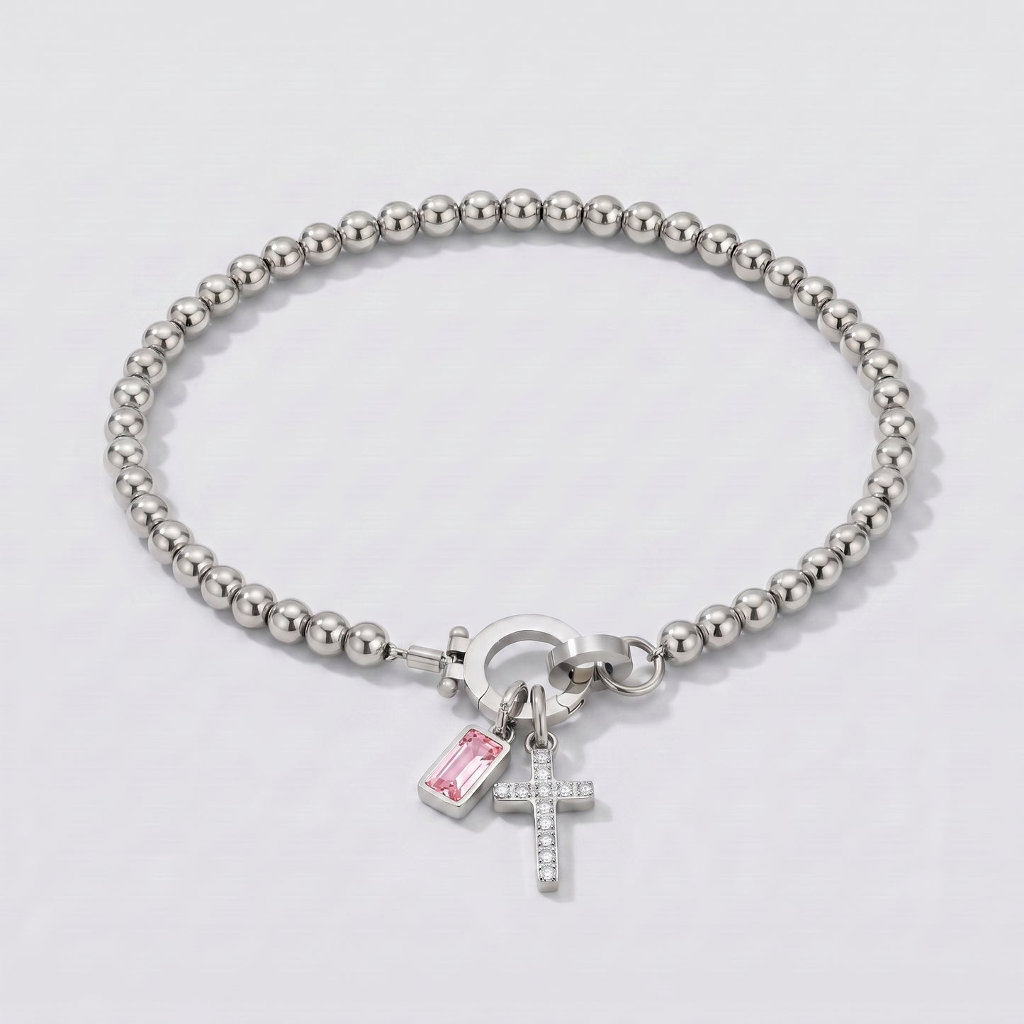 Pulseira prateada de contas com cruz e pedra de nascimento turmalina rosa de outubro.
