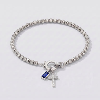 Pulseira prateada de contas com cruz e pedra de nascimento safira azul de setembro.