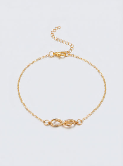 Pulseira dourada delicada com símbolo infinito e acabamento brilhante, fotografada sobre fundo claro para um visual elegante, feminino e minimalista.
