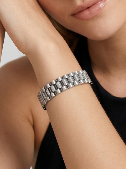 Pulseira prateada com design de elos largos e acabamento brilhante, usada no pulso para um visual elegante e sofisticado.